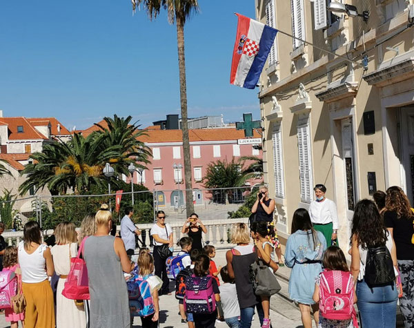 Fotografija učenika i roditelja ispred osnovne škole u Supetru